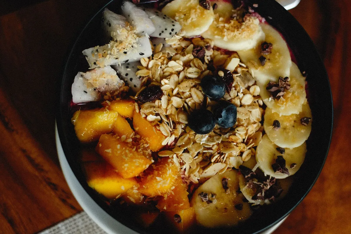 Bowl de desayuno con fruta y fibra sobre una mesa