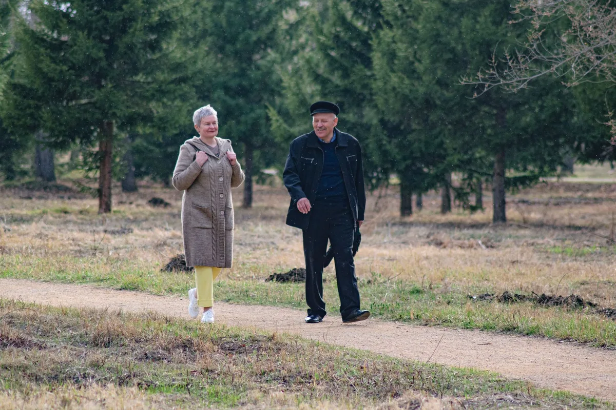 Pareja de adultos mayores caminando por un sendero