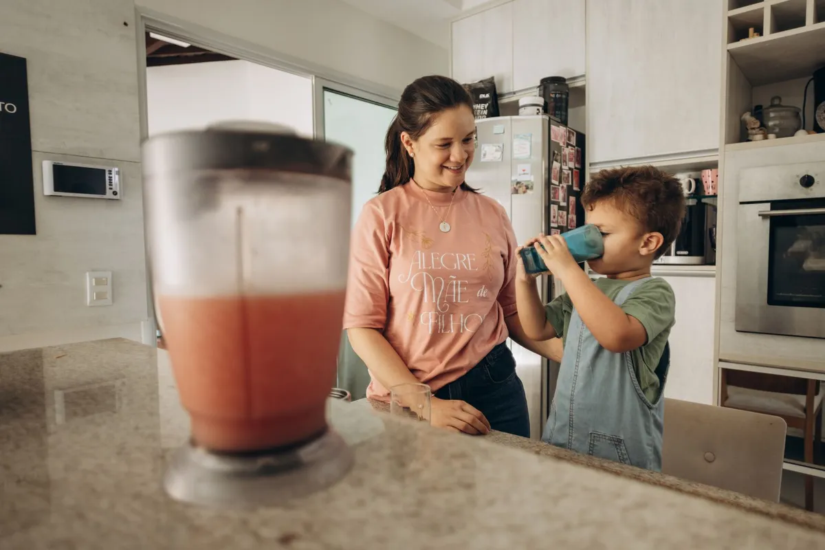 Mujer preparando un batido en la cocina por la mañana